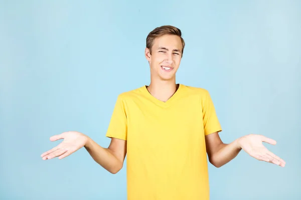 Portrait de jeune homme en t-shirt jaune sur fond bleu — Photo