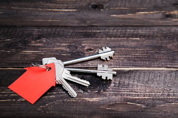 Silver key with house symbol on brown wooden table