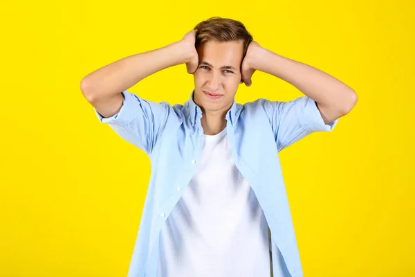 Young man having headache on yellow background — Stock Photo, Image