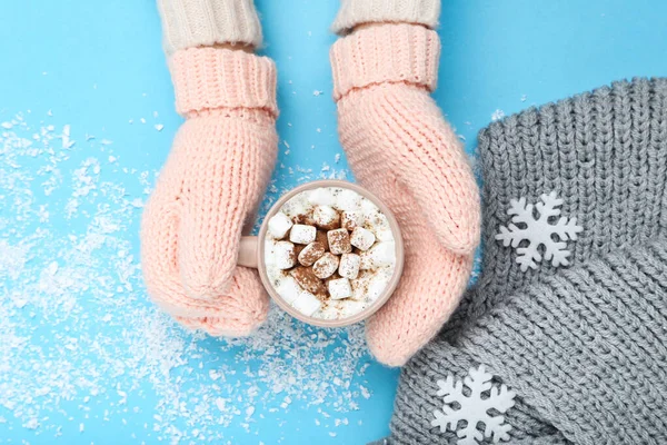 Hands in knitted mittens holding cup of coffee and grey scarf on — Stock Image Hands in knitted mittens holding cup of coffee and grey scarf on Stock Photo
