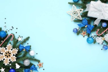 Oyuncak dolu Noel ağacı dalları ve mavi sırtüstü hediye kutusu