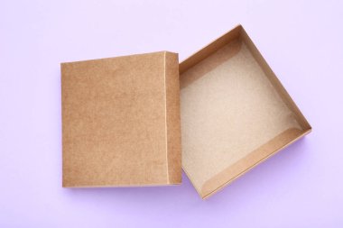 Mor arkaplanda kahverengi hediye kutusunu aç