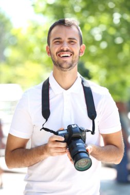 Şehirde kamerası olan genç bir fotoğrafçı.