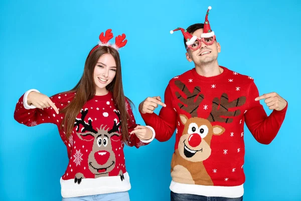 Hermoso hombre y mujer que usan suéteres de Navidad con cuerno rojo — Foto de Stock