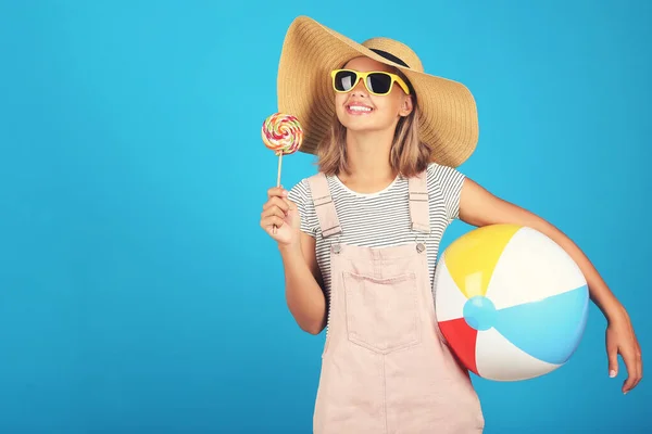 Mladá dívka nosí sluneční brýle, klobouk a drží lízátko a infl — Stock fotografie