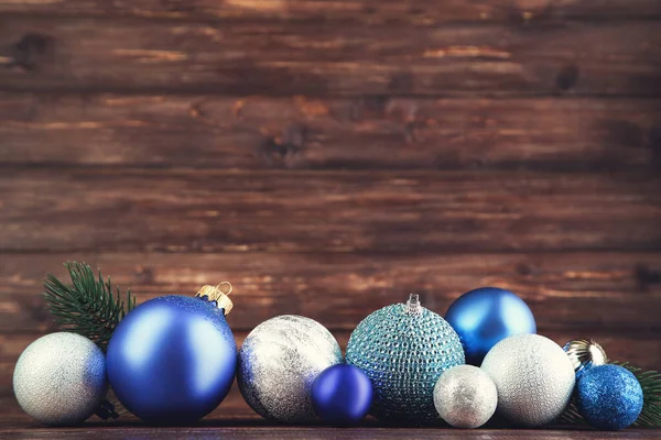 Bolas de Navidad con ramas de abeto sobre mesa de madera marrón —  Fotos de Stock