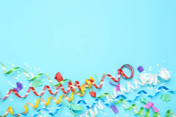 Colorful ribbons with confetti on blue background — Stock Photo, Image