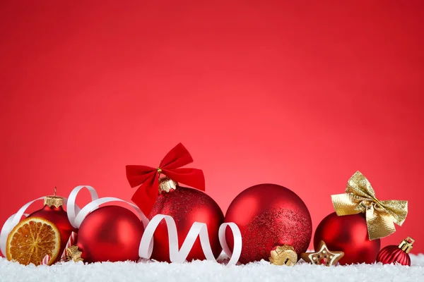 Kerst ornamenten met droge sinaasappels op rode achtergrond — Stockfoto