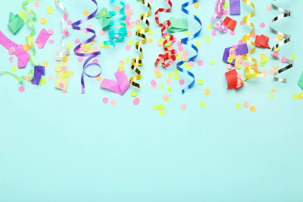 Colorful ribbons with confetti on blue background — Stock Photo, Image