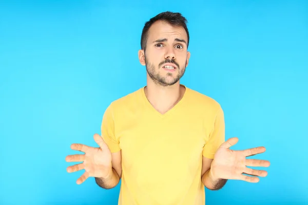 Portrait of young surprised man on blue background — 图库照片