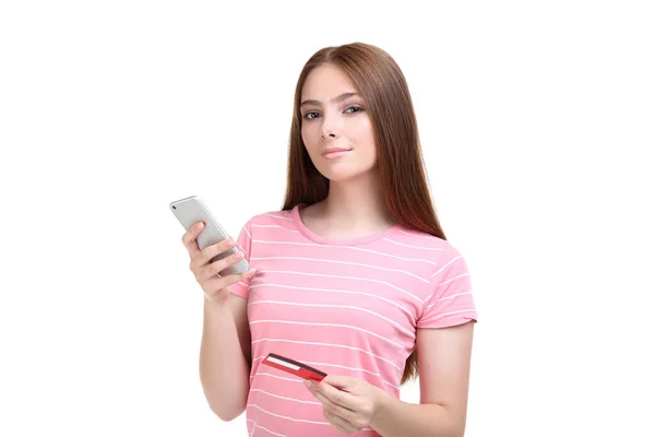 Young woman holding credit card and smartphone on white backgrou — Stock Photo, Image