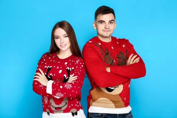 Hermoso hombre y mujer en suéteres de Navidad sobre fondo azul —  Fotos de Stock