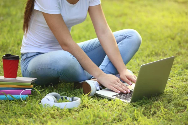 Młoda dziewczyna za pomocą laptopa komputer ze słuchawkami i książek na th — Zdjęcie stockowe