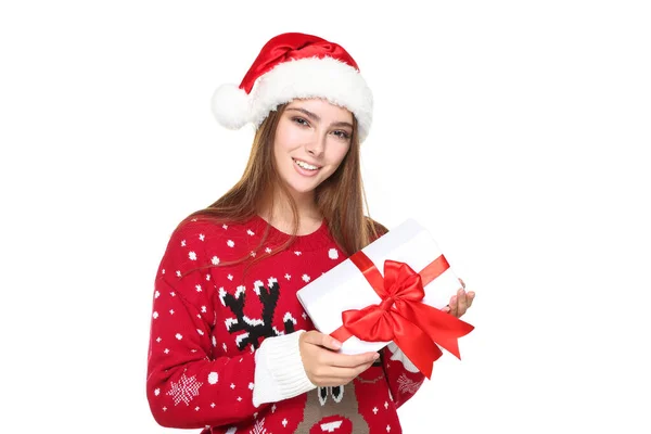 Piękna kobieta w świątecznym swetrze, kapeluszu Mikołaja i pudełku prezentów na białym tle — Zdjęcie stockowe
