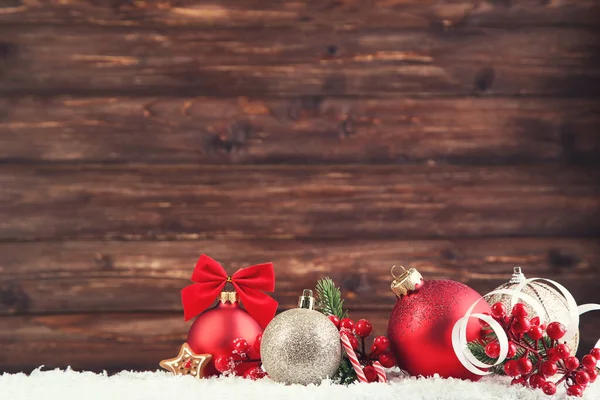 Palle di Natale con bacche rosse e caramelle sul dorso di legno marrone — Foto Stock