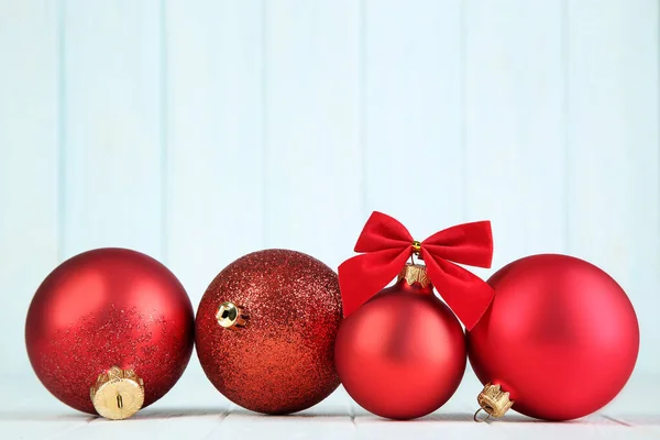 Χριστουγεννιάτικες μπάλες με κόκκινο φιόγκο σε ξύλινο φόντο — Φωτογραφία Αρχείου