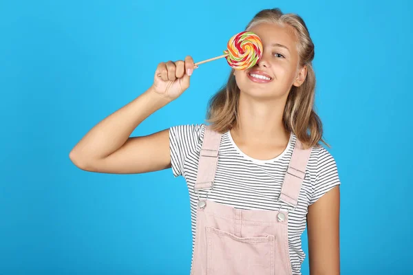 Retrato de niña sosteniendo piruleta sobre fondo azul —  Fotos de Stock