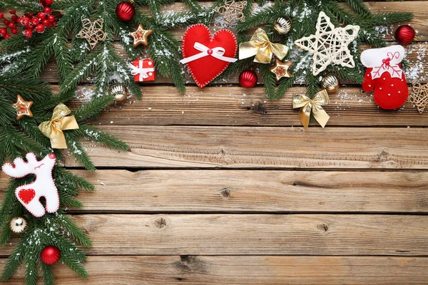 Kerstboom takken met speelgoed op bruine houten tafel — Stockfoto
