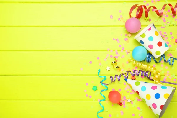 Kleurrijke linten met ballonnen en papieren kopjes op groene houten ba — Stockfoto