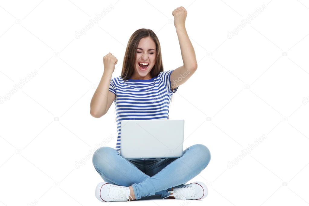 Young girl with laptop computer sitting on white background