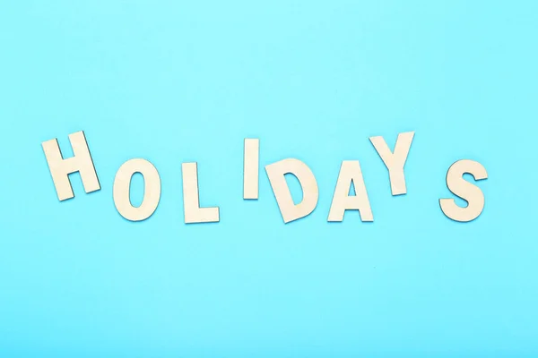 Word Holidays by wooden letters on blue background — Stock Photo, Image