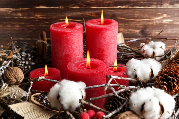 Рождественские свечи с цветами хлопка и шишками на коричневом дереве — стоковое фото