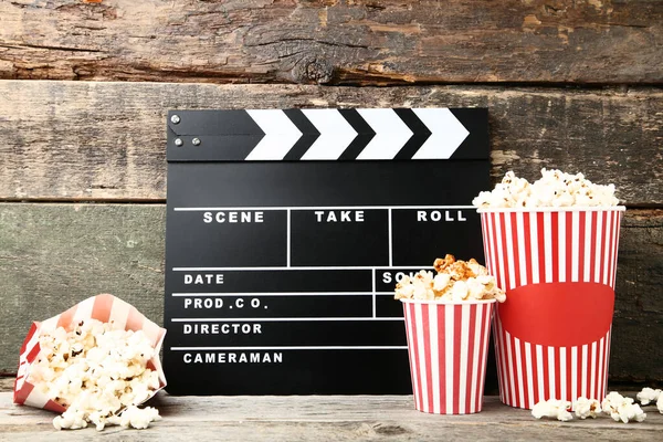 Tablero Clapper con palomitas de maíz sobre mesa de madera gris — Foto de Stock