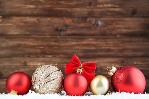 Bolas de Natal com arco vermelho no fundo de madeira marrom — Fotografia de Stock