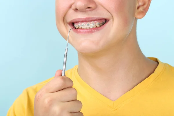 Joven con herramienta de dentista sobre fondo azul — Foto de Stock