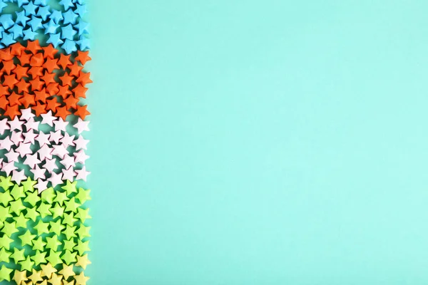 Coloridas estrellas de papel sobre fondo azul — Foto de Stock