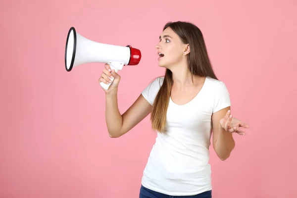 Mujer joven con megáfono sobre fondo rosa — Foto de Stock