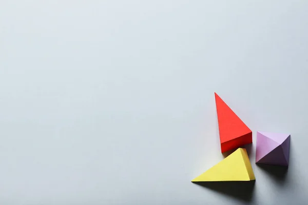 Барвисті паперові геометричні фігури на сірому фоні — стокове фото