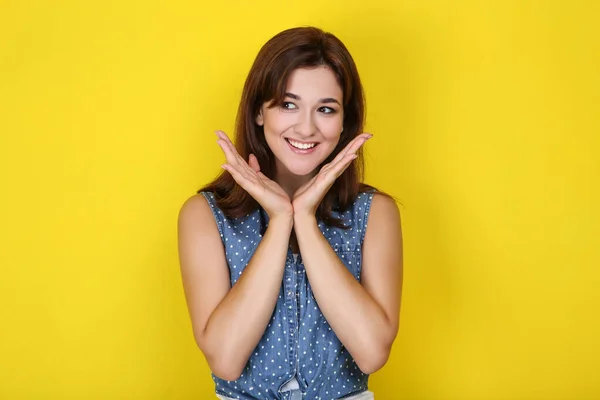 Jonge vrouw in stijlvolle kleding op gele achtergrond — Stockfoto