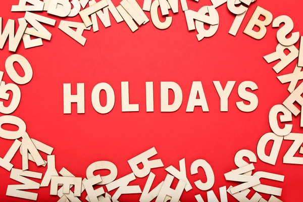 Word Holidays door houten letters op rode achtergrond — Stockfoto