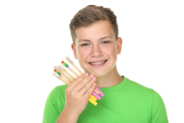 Молодий чоловік тримає зубні щітки ізольовані на білому тлі — стокове фото