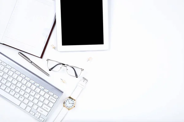 Tablet, tangentbordsdator med glasögon och anteckningsblock på vit rygg — Stockfoto