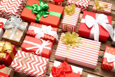 Kahverengi ahşap masada kurdeleli hediye kutuları.