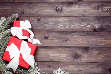 Kahverengi tahta masanın üzerinde köknar ağacı dalları olan hediye kutuları.