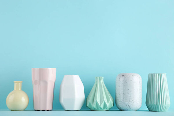 Различные керамические вазы на синем фоне
