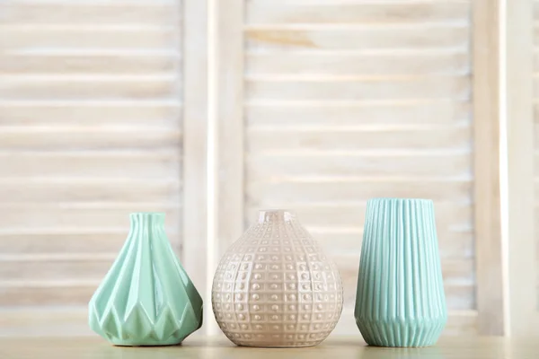 Diferentes jarrones de cerámica sobre fondo de madera — Foto de Stock