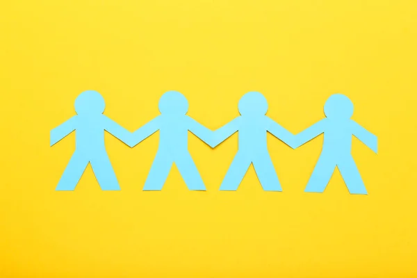 Paper chain people on yellow background — Stock Photo, Image