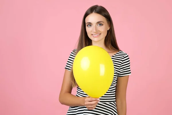 Wanita muda dengan balon di latar belakang merah muda — Stok Foto