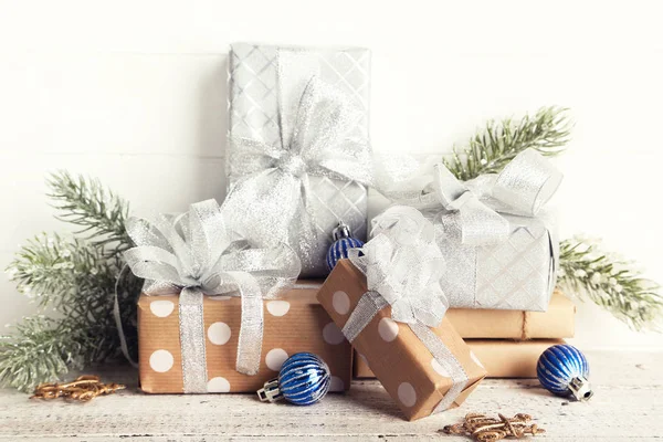 Cajas de regalo con adornos y ramas de abeto sobre madera blanca — Foto de Stock
