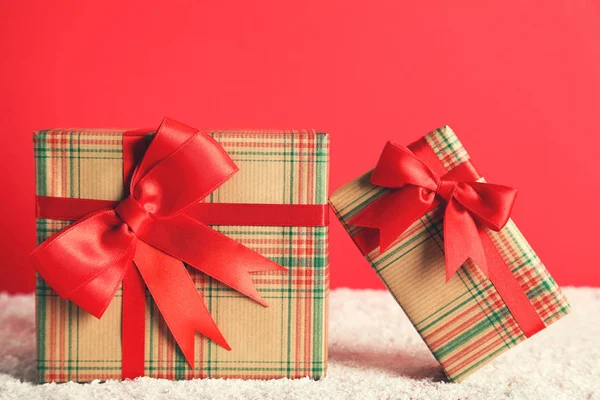 Gift boxes with ribbons on red background — Stock Photo, Image