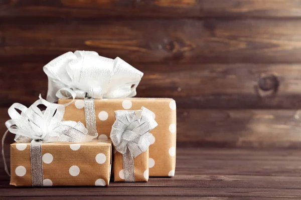 Geschenkboxen mit Bändern auf braunem Holztisch — Stockfoto