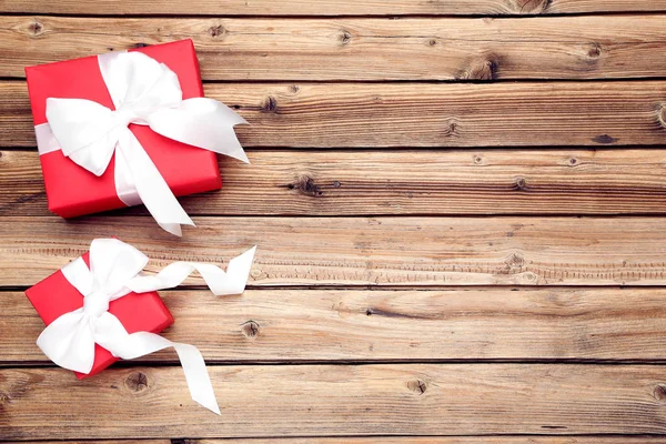 Gift boxes with ribbons on brown wooden table — Stock Photo, Image