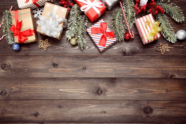 Geschenkboxen mit Tannenzweigen und Ornamenten auf braunem Holz — Stockfoto
