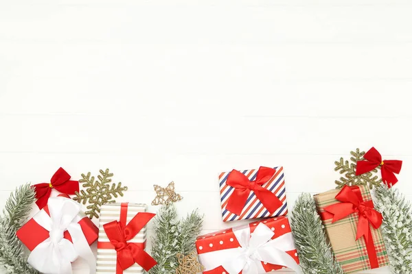 Geschenkboxen mit Ornamenten und Tannenzweigen auf weißem Holz — Stockfoto