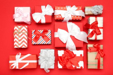 Kırmızı zemin üzerinde kurdeleler olan hediye kutuları