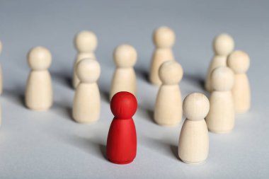 Lider konsepti. Gri arkaplanda tahta figürler
